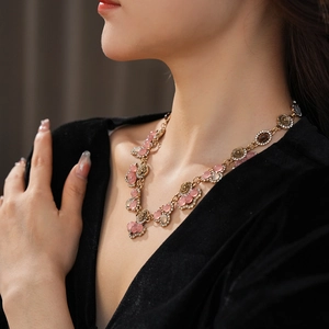 Close-up of vintage gold flower necklace with tiger eye stone and crystals on a model