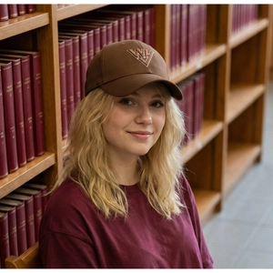 Nahaufnahme einer dunkelbraunen Baseballkappe mit WY-Stickerei, getragen von einem Model