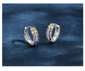 Macro shot of 925 silver hoop earrings with colorful rectangular zircons and diamonds