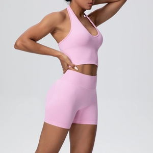 Detail of pink ribbed seamless yoga set showing halter top and high-waisted shorts