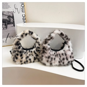 Detail of plush crescent handbag with leopard pattern and black leather strap