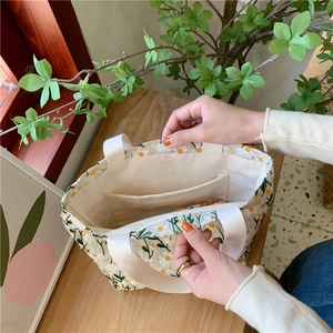 Détail du sac en toile beige avec broderies marguerites et structure de poche interne