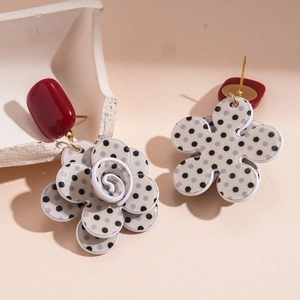 Detail of vintage acrylic floral earrings with red and black polka dot layered petals