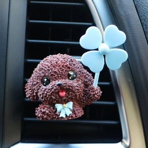 Close-up of cute Teddy Style dog car air vent clip with blue clover windmill on AC outlet