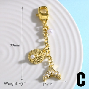 Detail view of gold mermaid tail and starfish charm keychain with measurements and weight