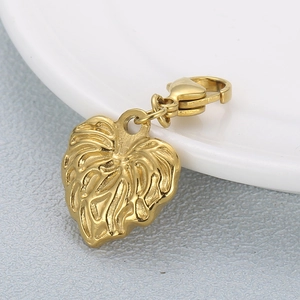Golden leaf-shaped metal keychain with detailed veins and lobster clasp on grey surface
