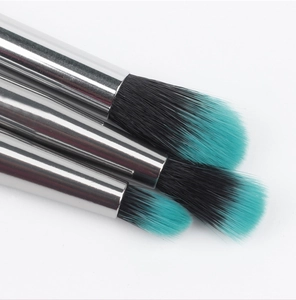 Detail of teal gradient synthetic bristles and silver metal ferrule on makeup brushes