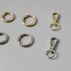 Close-up of polished gold and silver O-rings and carabiner clips for bag accessories
