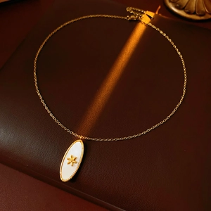 Detail of vintage oval pendant with gold starburst on textured leather background