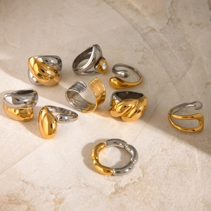 Two-tone mixed gold and silver stainless steel rings on a natural stone surface