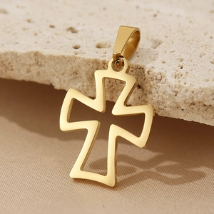 Detailed view of a gold hollow cross pendant on a textured stone surface with soft lighting
