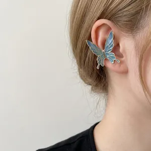 Elegant butterfly ear cuff with blue gradient enamel worn on a female ear