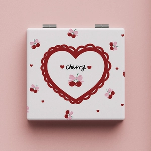 Close-up of portable square mirror with cute cherry and pink bow design on a soft pink base