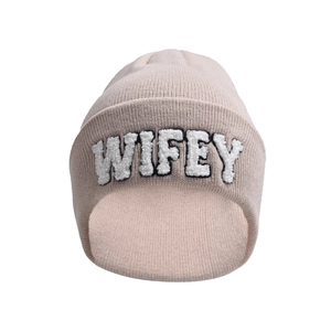 Detail of light pink knitted beanie featuring white fuzzy WIFEY embroidery texture