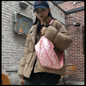 Close-up of pink quilted puffer fanny pack with matching textile strap and zipper