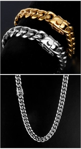 Detail of gold and silver Cuban chain bracelets and necklace with textured box clasp