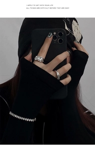 Close-up of irregular lava textured silver rings and sparkling bracelet on model hand