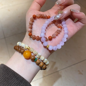 Close-up of double-layered beaded bracelet featuring natural stones and shell beads