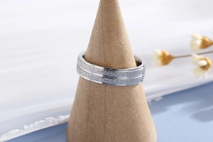 Close-up of a silver matte finish stainless steel ring on a wooden cone display stand