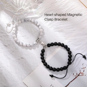 Dettaglio della chiusura magnetica a cuore tra bracciali in perline di marmo e nero opaco