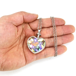 Handheld heart-shaped necklace filled with colorful crushed natural gemstones on silver chain