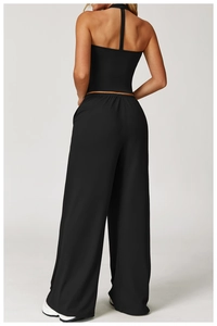 Back view of a black high-waisted wide-leg yoga set with a halter neck sports top