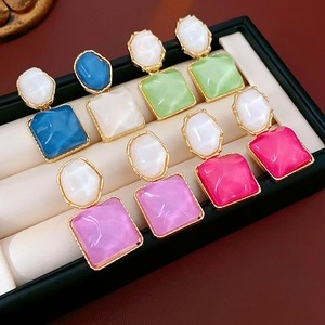 Detailansicht bunter Resin-Ohrringe mit Goldrahmen und unregelmäßiger Geometrie