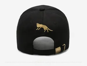 Detailed back view of black baseball cap featuring golden wolf embroidery and metal buckle