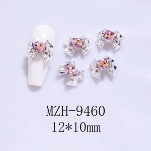 Detailed view of silver bow nail charms with 12x10mm pink heart rhinestones