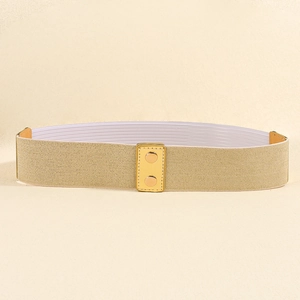 Detail van beige elastische riem met rechthoekige gouden metalen gesp en ronde studs
