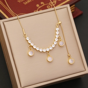 Elegant gold five-star zircon necklace with tassels and y-shape drop on a beige jewelry box