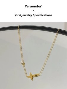 Detail of gold cross pendant with a round zircon stone reflecting on a mirror surface