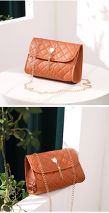 Detail of caramel brown quilted bag featuring cat ear decor and golden fringe tassel