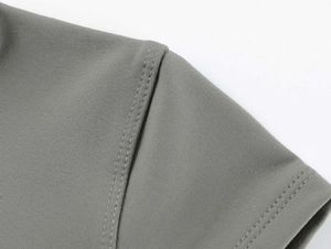 Detailed macro view of dark grey athletic T-shirt showing fine fabric texture and shoulder seams