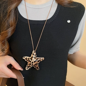 Close-up of leopard print star heart pendant necklace with stitched leather details
