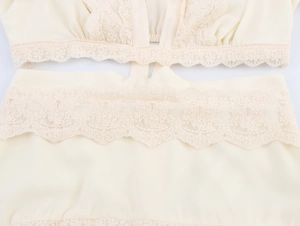 Détail de la dentelle crème délicate et de la broderie florale sur la robe en mousseline