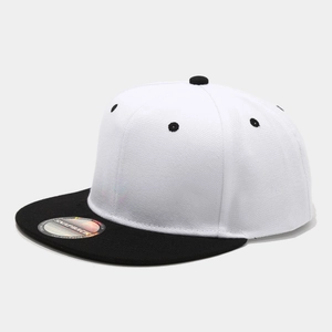 Dettaglio di un cappello snapback bicolore con corona bianca, visiera nera ed etichetta laser