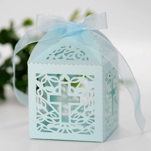Detailed macro view of laser-cut light blue favor box with cross and ribbon bow