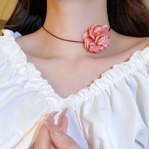 Close-up of a pink fabric flower choker necklace worn on a neck for aesthetic style