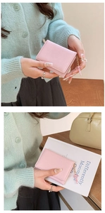 Portafoglio corto in pelle PU rosa con ciondolo a fiocco tenuto da modella in ambiente