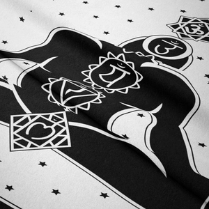 Detailed macro view of black and white chakra and om symbol patterns on bohemian tapestry fabric