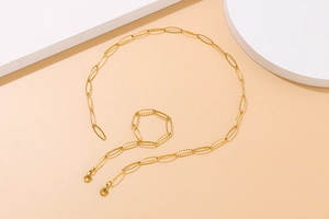 Detail of gold paperclip chain necklace with textured oval links and lobster clasp closure