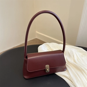 Retro wine red PU leather baguette shoulder bag with gold buckle on display