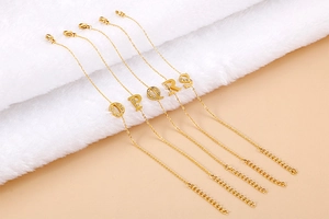 Detailed view of gold plated initial bracelets O-S with sparkling rhinestones set