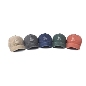 Five washed cotton baseball caps with embroidered cartoon dogs in multiple colors