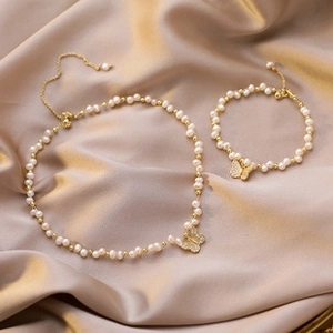 Detailed close-up of 14K gold plated baroque pearl jewelry set with butterfly pendants