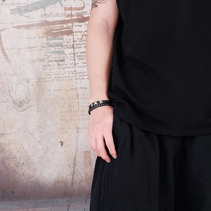 Men wear woven multi-layer leather bracelet with cross metallic charm on wrist