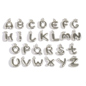 Makroansicht von 26 silbernen Metallanhängern in Großbuchstaben mit glattem Finish