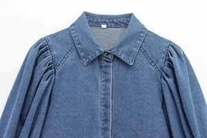 Detail of blue denim shirt featuring a classic collar and elegant puff sleeves design