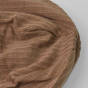Macro shot of brown rib-knit beanie showing detailed texture and stitching quality